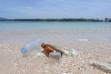 Beach pollution. Plastics and glass rabbish on the sea beach.