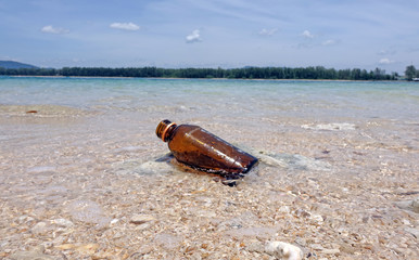 Fototapeta na wymiar Beach pollution : Glass bottle on the sea beach.