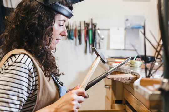 Side view of female craftsperson working in workshop