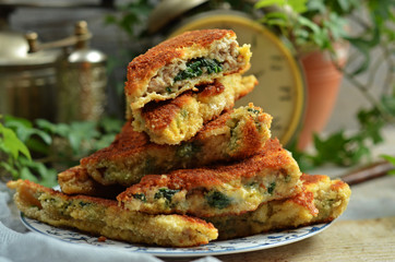 Minced pork chops with spinach stacked on a saucer