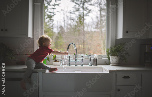 Side view of girl washing hand in sink