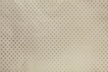 Light beige background from metal foil paper with a stars pattern