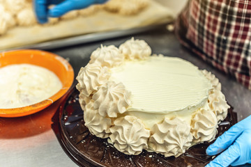 Pastry chef in gloves cooking meringue cake and desserts. Production of confectionery