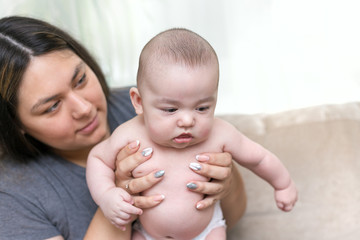 Mother is holding her newborn infant son