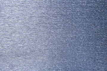 Textural of silver background of wavy corrugated paper, closeup.
