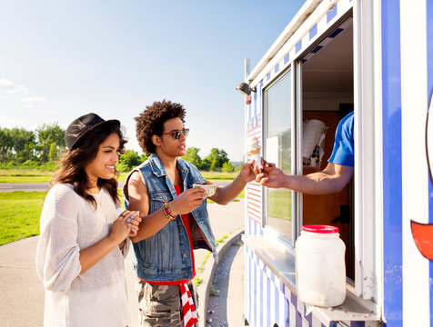 Friends buying ice cream from vendor at food truck