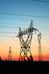 In the evening, the silhouette of high voltage towers