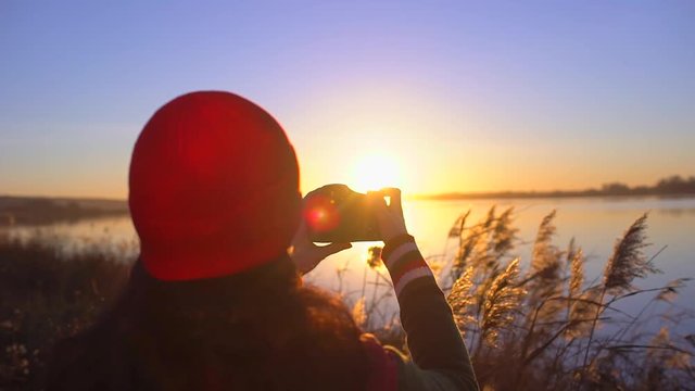 tourist teen girl traveler female photographer photographing, girl making photo of beach lake. Woman taking picture of camera at sunset. summer nature outdoors Travel tourism happy holidays photograph