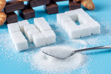 Text No is lined with sugar cubes and sweets. Harm to the health of sweet and rejection of sucrose