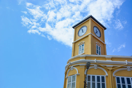 yellow building with clock tower in Chino-Portuguese style on blue sky background, Phuket old town, Thailand, copy space
