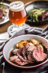 Sliced Beef tenderloin roasted steak potatoes rosemary and draft beer