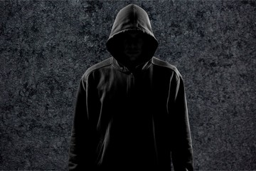 Dark unrecognisable man in hoodie on background
