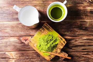 Top view of a cup of Matcha tea with milk jug.