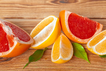 Grapefruit with slices on a wooden table.