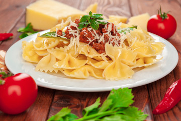 Pasta with meat, tomato sauce and vegetables on the table