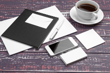 Branding stationery mockup on purple desk. Top view of paper,  business card, pad, pens and coffee.