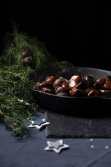 Fried chestnuts with sea salt in rustic pan served on blue table cloth