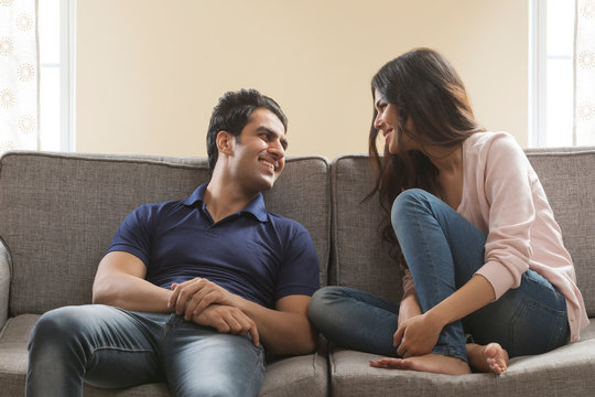 Young couple sitting on sofa at home	
