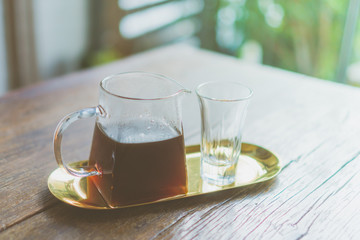 Black coffee or Americano on table with film vintage tone background.