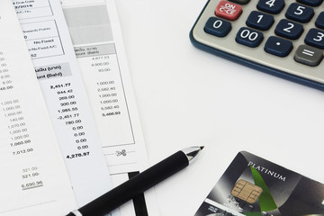 close up of a credit cards with credit card statements, pen and calculator on white background,...