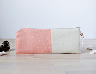 Handmade cotton pencil case with beads on the wooden table