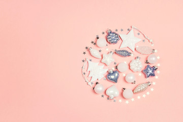 Round festive composition of white and blue decorations with copy space on pink background.