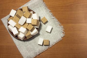 a plate with white and cane sugar on a linen napkin on a wooden table