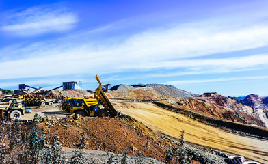 View of opencast mining quarry with lots of machinery at work