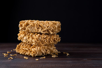 Instant noodles close up on wooden table over black background with copy space