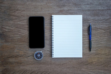 Top view, flat lay office supply note book, pen and compass and smartphone with a cut wood number...