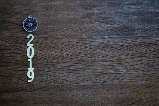 Top View, Flat Lay Compass And A Cut Wood Number 2019 On Wood Table