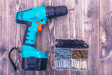 Modern rechargeable screwdriver and screws in box close up