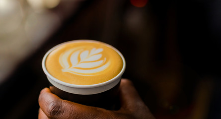 African Coffee Barista holding a take away cup