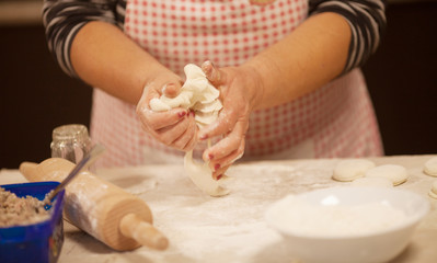 Obraz na płótnie Canvas Woman kneading dough on table, closeup