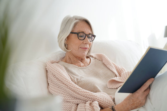 Beautiful Senior Woman Relaxing In Bed Reading