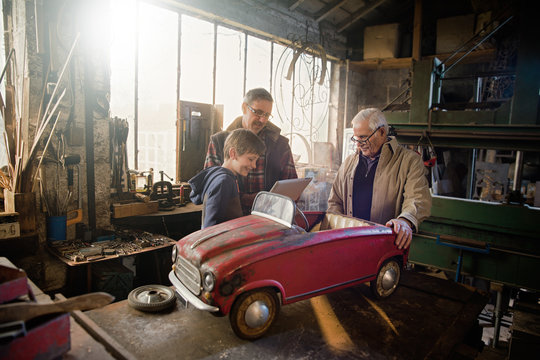 Multi generation family in aDIY workshop to repair a pedal car