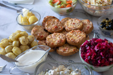 Food for the holiday of Christmas and New Year in Russia. Festive table. Various traditional dishes and snacks. View from above. Baked potatoes, salad, sandwiches