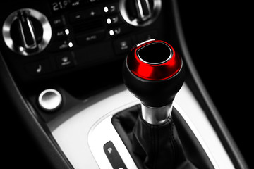 Red Automatic gear stick of a modern car. Maodern car interior details. Close up view. Car...