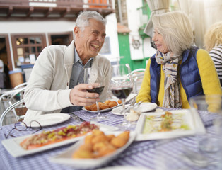 Fototapeta na wymiar Attractive senior couple eating tapas outdoors