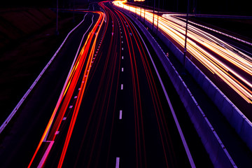 Cars light trails on a curved highway at night. Night traffic trails. Motion blur. Night city road...
