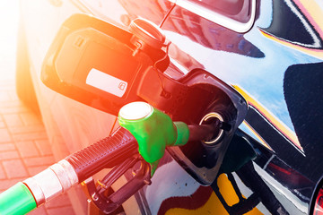 Refueling the car at a gas station fuel pump. Man driver hand refilling and pumping gasoline oil...