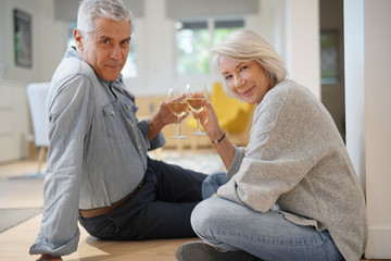  Romantic modern senior couple sharing glass of wine at home