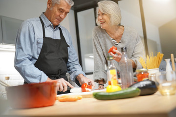  Senior couple couple cooking together in modern kitchen