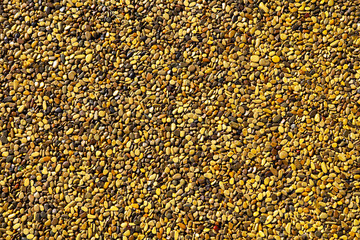 Small yellow stones on the road surface as background