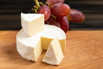 Cheese and grapes on a dark background