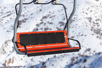 Ski lift and snowboarders in the mountains