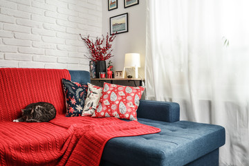 Christmas decorations with candles and red plaid on couch