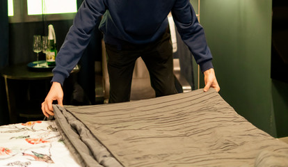 close up young man making a bed at home bedroom v