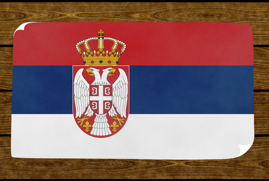Illustration of a Serbian flag on the paper pasted on the woody wall
