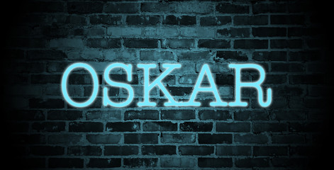 first name Oskar in blue neon on brick wall